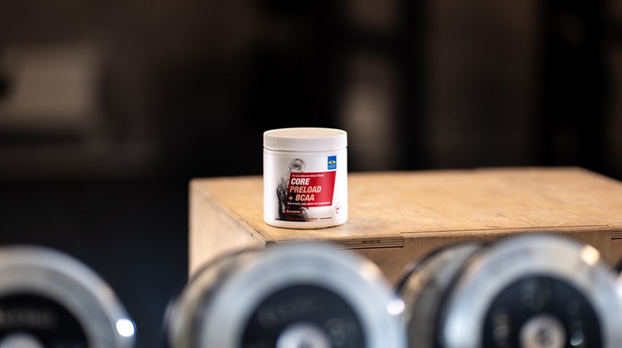 Purkki Core Preload + BCAA:ta puisen laatikon p��ll� saliymp�rist�ss�.